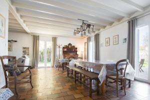 a dining room with a table and chairs at Villa PIERROT avec grand jardin arboré, proche du port et des restaurants in La Flotte
