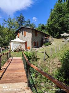 a wooden walkway leading to a building with a tent at Agriturismo il canale in Corfino
