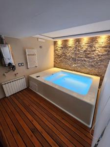 a large bath tub in a room with a stone wall at Alquilo Casa Luminosa y Amplia en Viedma in Viedma