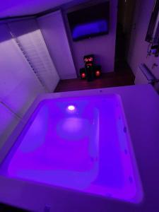 a purple bath tub in a room with a tv at Alquilo Casa Luminosa y Amplia en Viedma in Viedma
