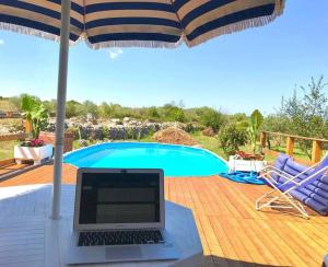 a laptop sitting on a table next to a swimming pool at Villa delle Stelle in Cassaro