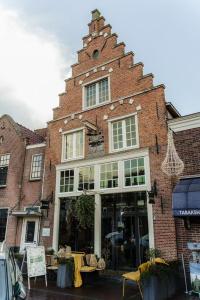 een groot bakstenen gebouw met een winkelgevel bij Bed bij Bistro in Medemblik