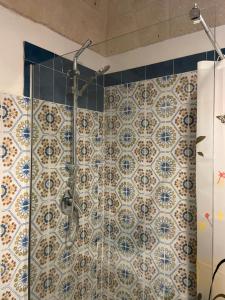 a bathroom with a shower with blue and white tiles at Dimora Storica Monopoli in Monopoli