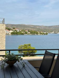 a table and chairs on a balcony with a view of the water at Luxury Old Town Apartment with Sea View in Rogoznica