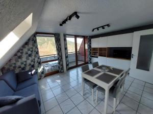 a living room with a table and a blue couch at Appartement T2 45m² avec terrasse - 4/6 personnes in Le Mont-Dore