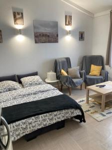 a bedroom with two beds and chairs and a table at Studio Chez Bob in Montreuil