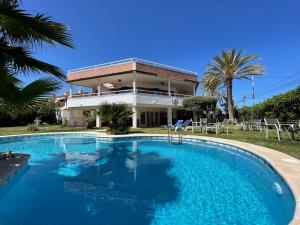 a large swimming pool in front of a house at Anna's garden in Torrevieja