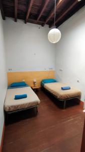 a room with two beds and a light fixture at Hostel Albergue La Casa Encantada in El Paso