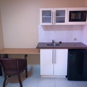a small kitchen with a sink and a microwave at 101 Suites in Paramaribo