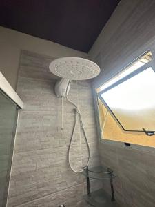 una ducha en la esquina de una habitación con ventana en Casa na Grande Florianopolis en Palhoça
