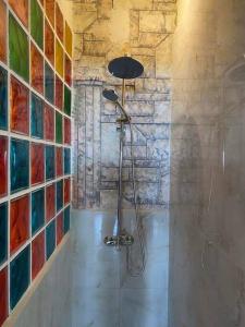 a bathroom with a shower with colorful tiles on the wall at Athens Victoria's Apartment in Athens
