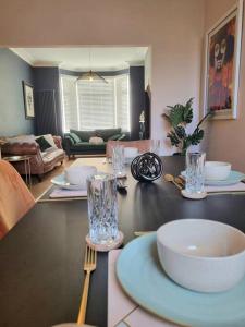 a living room with a table with plates and glasses at Contemporary Spacious 3BR House close to City Centre in Wyken