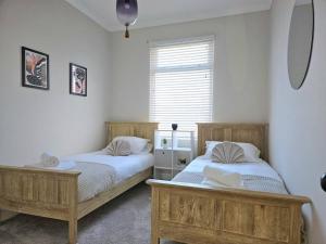 two beds sitting next to each other in a bedroom at Contemporary Spacious 3BR House close to City Centre in Wyken