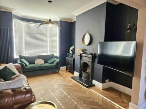 a living room with a couch and a fireplace at Contemporary Spacious 3BR House close to City Centre in Wyken