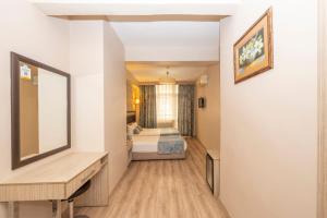 Habitación con dormitorio con cama y espejo. en Tugra Hotel, en Estambul