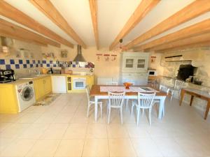 a kitchen with a table and chairs and a stove at La Maison de Margot in Xaintray