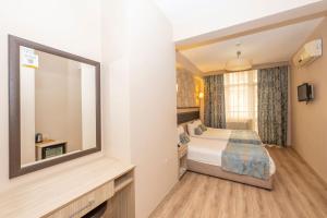 a hotel room with a bed and a mirror at Tugra Hotel in Istanbul