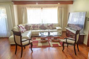 ein Wohnzimmer mit einem Sofa, einem Tisch und einem Klavier in der Unterkunft Casa céntrica por día en Pucón in Pucón