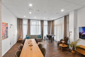 Flatista Homes - Aubing في ميونخ: غرفة معيشة مع طاولة طويلة وأريكة