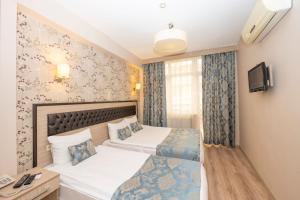 Habitación de hotel con 2 camas y TV en Tugra Hotel, en Estambul
