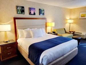 a hotel room with a large bed and a chair at Bangor Grande Hotel in Bangor