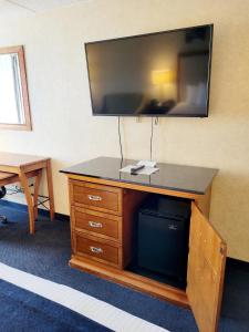 a large flat screen tv on top of a dresser at Bangor Grande Hotel in Bangor