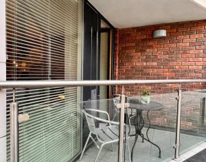a table and chair on a balcony with a brick wall at Cosy and modern Bedroom in the heart of Dublin in Dublin