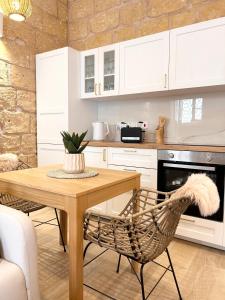 a kitchen with a wooden table and a chair at MCC Argotti House in Il-Furjana