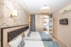 イスタンブールにあるトゥーラ ホテルのベッド2台と窓が備わるホテルルームです。
