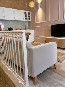a white crib in a living room with a tv at MCC Argotti House in Il-Furjana