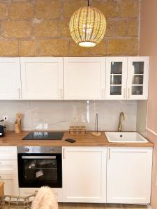 a kitchen with white cabinets and a sink at MCC Argotti House in Il-Furjana +18 photos