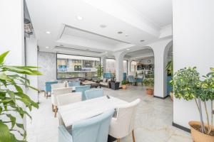 a restaurant with white tables and chairs and plants at Tugra Hotel in Istanbul