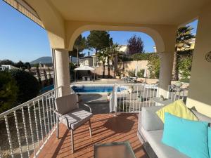 un porche avec un canapé et des chaises à côté d'une piscine dans l'établissement Pinada del Rio Villa, Alicante, à Tibi