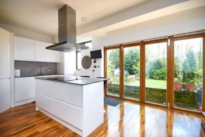 cocina con armarios blancos y ventana grande en Large London home with Free parking, en Winchmore Hill