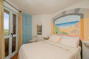 1 dormitorio con 1 cama y una pintura en la pared en Casa Lilly by Wonderful Italy en Porto Cervo