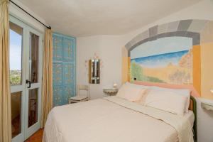 Un dormitorio con una cama y un cuadro en la pared. en Casa Lilly by Wonderful Italy, en Porto Cervo