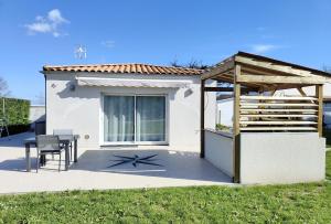 Casa blanca con mesa y techo de madera en Manava, en Vaux-sur-Mer