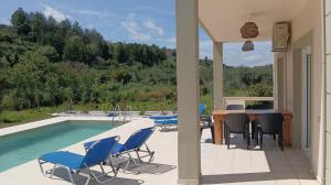 un patio con mesa y sillas junto a una piscina en Villa Evridiki, en Georgioupolis