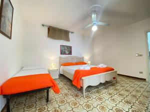 een slaapkamer met 2 bedden en een plafondventilator bij Marini Apartment by Diddoi in Marina di Mancaversa