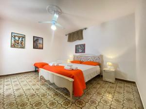 een slaapkamer met een bed en een plafondventilator bij Marini Apartment by Diddoi in Marina di Mancaversa