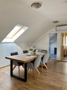 comedor con mesa de madera y sillas en Home Sweet Apartment XL, en Bükfürdő