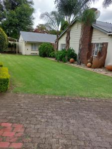 a house with a lawn with pumpkins in the yard at Lushof Guesthouse in eMalahleni