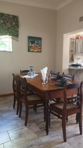 uma mesa de jantar em madeira com cadeiras numa cozinha em Lushof Guesthouse em Witbank