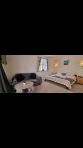 a living room with two beds and a couch at 3 Bedroom Bungalow with great Sea Views, Private Hot Tub & Gardens in Paignton