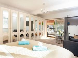 a bedroom with a large white bed and a couch at 3 Bedroom Bungalow with great Sea Views, Private Hot Tub & Gardens in Paignton