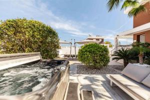 Puerto MarinoにあるCasa Bos Orange Wellness Luxury Entire Villa Jacuzzi & Pool Gran Alacant near Beachの家の裏庭にあるホットタブ