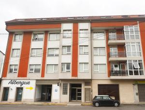 a building with a car parked in front of it at Apartamento O SALEIRO in Padrón