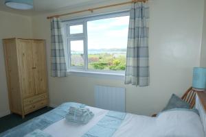 a bedroom with a bed and a window at Tir Nan Og in Rockcliffe