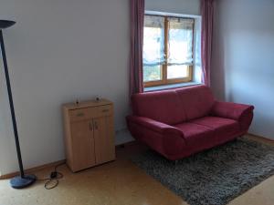a living room with a red chair and a window at Ferienwohnung Apfelgarten in Oberkirch