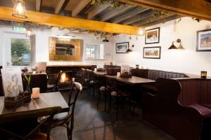 a restaurant with tables and chairs and a fireplace at The Wordsworth Hotel in Grasmere